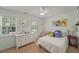 Cozy bedroom featuring colorful artwork, plush pillows, and natural light from two windows at 739 Wildwood Rd, Charleston, SC 29412