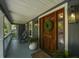 Inviting front porch with rocking chairs, a decorated front door, and lantern lighting at 739 Wildwood Rd, Charleston, SC 29412