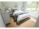 Inviting bedroom with a view of the yard, featuring two side tables, a white dresser, and light walls at 7621 Indigo Palms Way, Johns Island, SC 29455