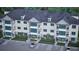 Aerial of multi-story condo building boasting balconies, lush landscaping, and accessible parking at 7621 Indigo Palms Way, Johns Island, SC 29455