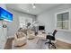 Bright home office featuring modern desk, stylish chairs, and a mounted television for work and leisure at 7621 Indigo Palms Way, Johns Island, SC 29455