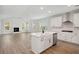 Open-concept kitchen with white cabinets, marble island, and views into the living room with a fireplace at 767 Maynard Ln, Summerville, SC 29486