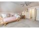 Attic bedroom featuring a rattan daybed, soft carpet, a ceiling fan, a desk and access to the attic at 777 Hamlet Cir, Goose Creek, SC 29445