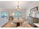 Dining area with stylish chandelier, wood table, and seating for six and views of the lush outdoors at 777 Hamlet Cir, Goose Creek, SC 29445