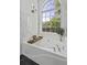 Bright bathroom featuring a soaking tub and a large arched window for natural light at 79 Rivers Point, Charleston, SC 29412