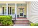 Charming front porch features white columns, sidelights, potted plants, and brick steps at 79 Rivers Point, Charleston, SC 29412