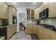 Well-lit kitchen with wooden cabinets, black countertops, and stainless steel appliances at 79 Rivers Point, Charleston, SC 29412