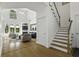Bright living room with hardwood floors, tall ceilings, fireplace, and staircase leading to the upper level at 79 Rivers Point, Charleston, SC 29412