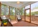Inviting screened porch featuring wood floors, ceiling fan, and two wicker chairs for outdoor enjoyment at 79 Rivers Point, Charleston, SC 29412
