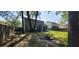 Expansive backyard with a fire pit, mature trees, and screened porch at 8107 Old London Rd, North Charleston, SC 29406