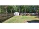 Fenced backyard featuring a storage shed and surrounding forest at 8107 Old London Rd, North Charleston, SC 29406