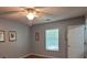 This bedroom features wood flooring, a ceiling fan and light, and windows with blinds for pleasant natural light at 8107 Old London Rd, North Charleston, SC 29406