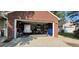 View of garage showing ample storage and a golf cart, adjacent to brick home at 8107 Old London Rd, North Charleston, SC 29406