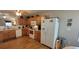 Well-equipped kitchen with wooden cabinets, white appliances, and hardwood flooring, offering a functional cooking space at 8107 Old London Rd, North Charleston, SC 29406