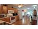 Bright kitchen featuring wooden cabinetry, white appliances, and a view into the dining area with hardwood floors at 8107 Old London Rd, North Charleston, SC 29406
