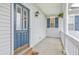 Welcoming front porch featuring a blue door with glass panels and a charming 