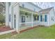 Inviting front porch with white columns, blue door, and hanging plants at 83 Creekside Dr, Summerville, SC 29485
