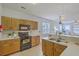 Traditional eat-in kitchen features wood cabinets, laminate countertops, black appliances and open access to living area at 83 Creekside Dr, Summerville, SC 29485