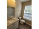 Bathroom has a single vanity and a window providing natural light, plus tiled floors at 9471 Netted Charm Ct, Ladson, SC 29456