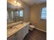 Bathroom featuring a double vanity, quartz countertop, and large mirror with a window for natural light at 9471 Netted Charm Ct, Ladson, SC 29456