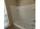 Bathroom offers a window for natural light and a combined shower-tub with white tile surround at 9471 Netted Charm Ct, Ladson, SC 29456