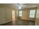 Bedroom with neutral walls and wood floors; features windows and a door to the ensuite bathroom at 9471 Netted Charm Ct, Ladson, SC 29456