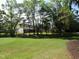Spacious grassy backyard lined with trees and fencing, providing privacy and a natural setting at 9677 Islesworth Way, Summerville, SC 29485