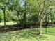 Well-maintained backyard featuring a lush lawn, mature trees, and a decorative black metal fence at 9677 Islesworth Way, Summerville, SC 29485