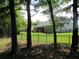 Secluded backyard view from behind the decorative black metal fence surrounded by mature trees at 9677 Islesworth Way, Summerville, SC 29485
