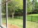 Backyard view from inside the house with a large grassy area and mature trees at 9677 Islesworth Way, Summerville, SC 29485