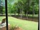 Scenic backyard view with a lush lawn, privacy fence, and mature trees at 9677 Islesworth Way, Summerville, SC 29485
