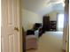 View of bedroom features beige carpet, light-yellow painted walls, television, shelving, and a mini-refrigerator at 9677 Islesworth Way, Summerville, SC 29485