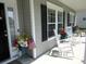 Inviting front porch with white rocking chairs, floral arrangements, and charming decor at 9677 Islesworth Way, Summerville, SC 29485