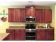 Modern kitchen with stainless steel appliances, wood cabinets, and light countertops at 9677 Islesworth Way, Summerville, SC 29485