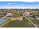 Aerial view displays two homes with red roofs amidst trees, near a waterway and the ocean at 1214 Tabby Dr, Folly Beach, SC 29439