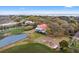 Stunning aerial view of a charming home with a red roof nestled among lush trees and serene waterways at 1214 Tabby Dr, Folly Beach, SC 29439