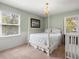 Bedroom featuring windows, four-poster bed, white wainscoting, and a crib at 1214 Tabby Dr, Folly Beach, SC 29439