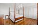 Bedroom with wood floors, four-poster bed, ceiling fan, and double closet at 1214 Tabby Dr, Folly Beach, SC 29439