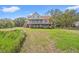 Charming elevated home with a red metal roof, a large yard, and scenic views at 1214 Tabby Dr, Folly Beach, SC 29439