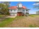 Charming home with a convenient garage, a welcoming porch, and a well-manicured lawn at 1214 Tabby Dr, Folly Beach, SC 29439