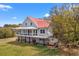 Lovely stilted home with a metal roof, charming balcony, and lush green surroundings at 1214 Tabby Dr, Folly Beach, SC 29439