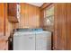 Laundry area with wood walls, a stacked washer and dryer, and a window for natural light at 1214 Tabby Dr, Folly Beach, SC 29439