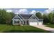 Charming home featuring a three-car garage, stone accents, and lush landscaping at 1022 Lacebark Dr, Ridgeville, SC 29472