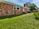 Brick house featuring a bay window, chimney, and a lush green backyard with blooming white flowers at 103 Sycamore Dr, Summerville, SC 29485