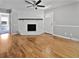 A spacious living room featuring beautiful hardwood floors, a white fireplace, and a ceiling fan at 103 Sycamore Dr, Summerville, SC 29485