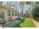 Inviting backyard features a patio, artificial turf, and mature trees offering a private outdoor space at 106 Sago Palm Ct, Summerville, SC 29483