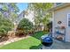 Landscaped backyard featuring artificial turf, a grill, and a charming garden area; perfect for outdoor entertaining at 106 Sago Palm Ct, Summerville, SC 29483