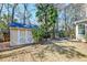 Well maintained shed nestled in a backyard with mature trees and a palm, offering extra storage at 106 Sago Palm Ct, Summerville, SC 29483