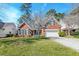 Charming brick home with a manicured lawn, mature trees, and a two-car garage at 106 Sago Palm Ct, Summerville, SC 29483