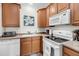 Efficient kitchen featuring white appliances, hardwood floors and wood cabinetry at 118 Congress St # F, Charleston, SC 29403